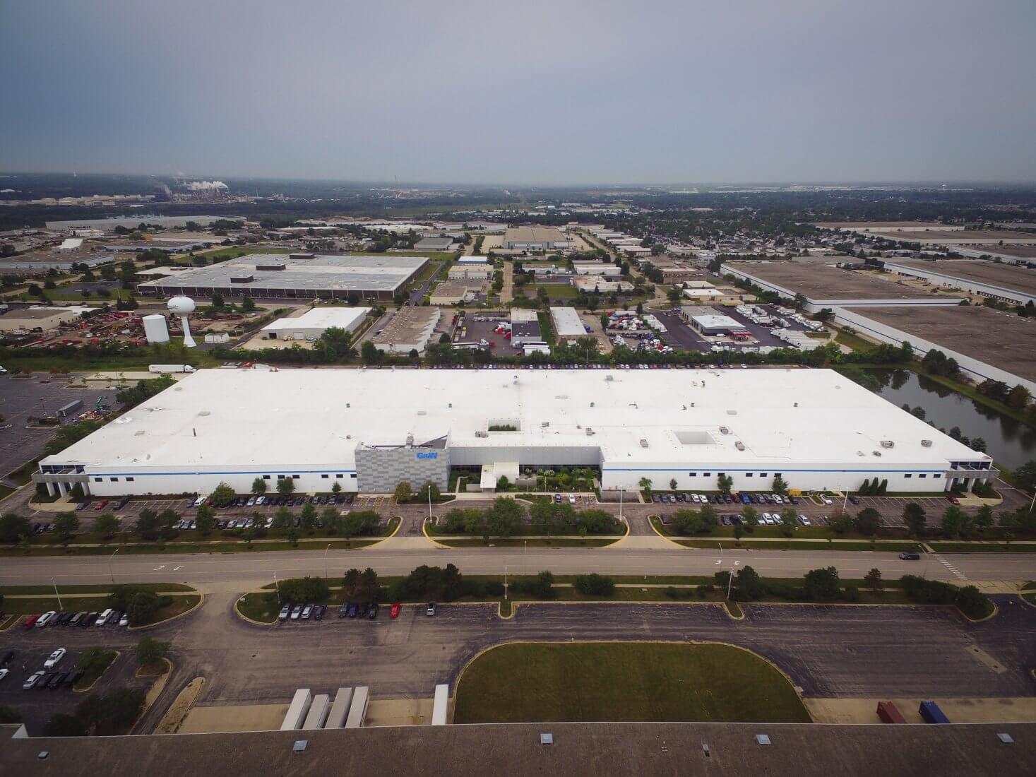 A large factory building with a white roof