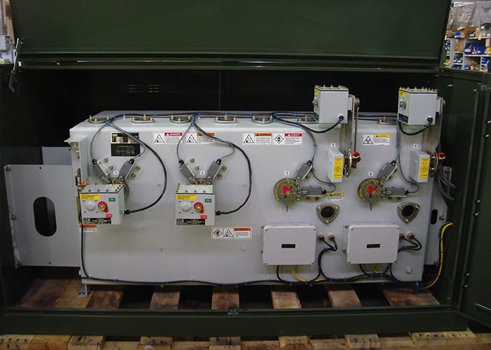 A grey switch sitting in a green cabinet