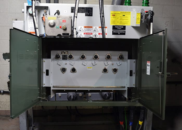 A grey switch inside a green cabinet