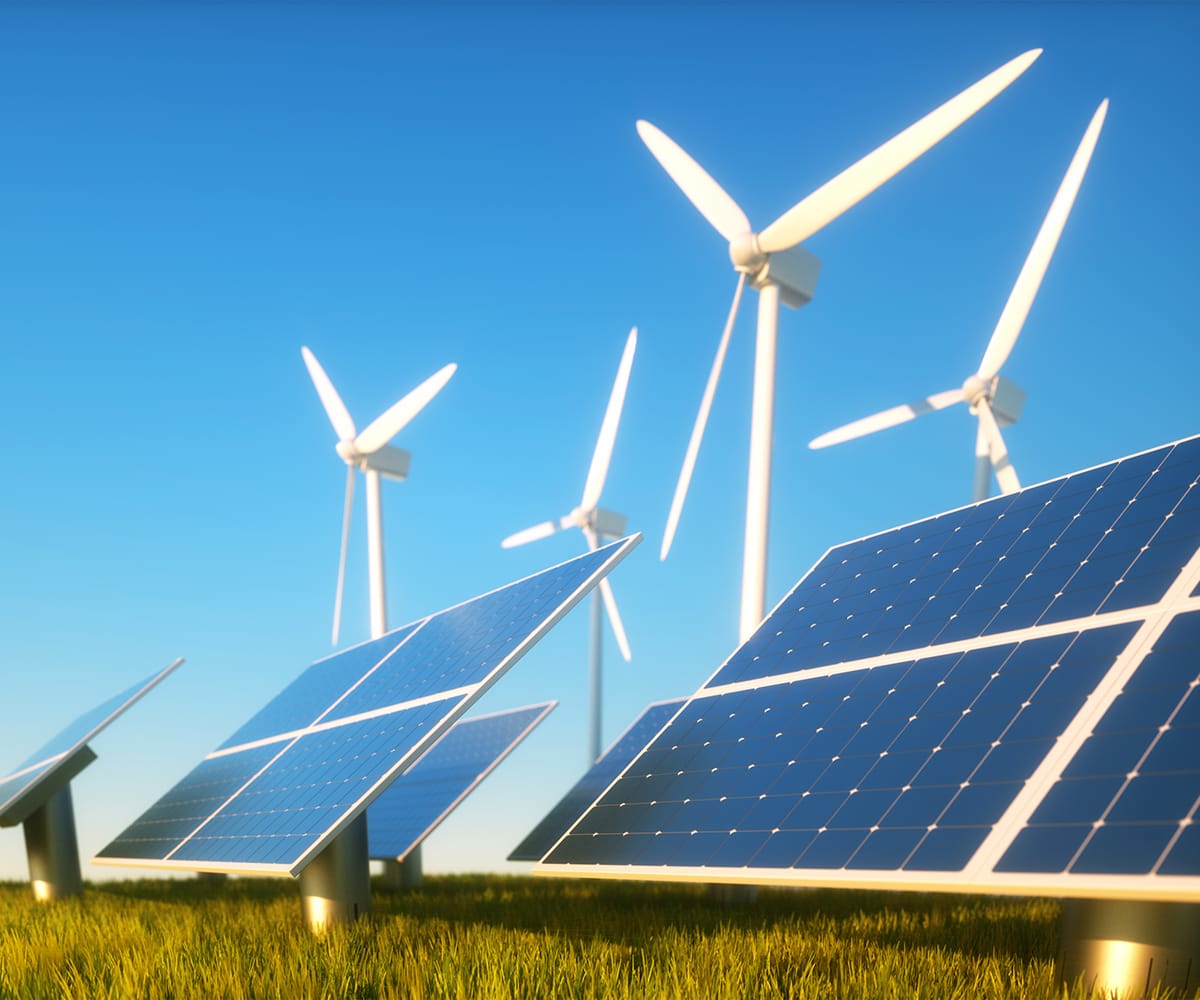 Molinos de viento y paneles solares en un campo.