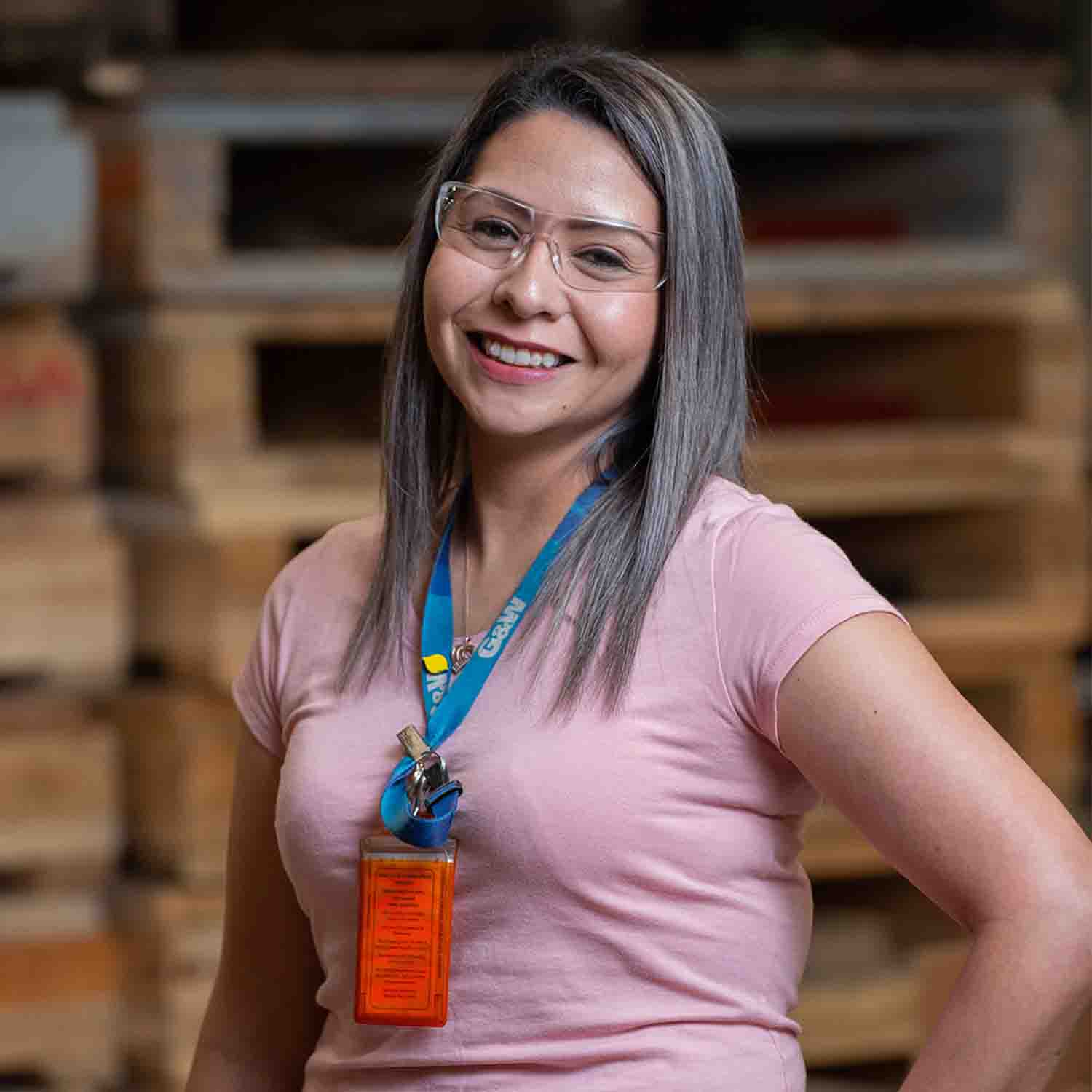 Mujer con gafas de seguridad en un almacén.
