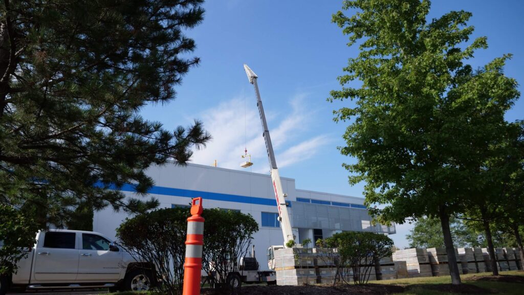 A crane lifting objects on to the roof of a building