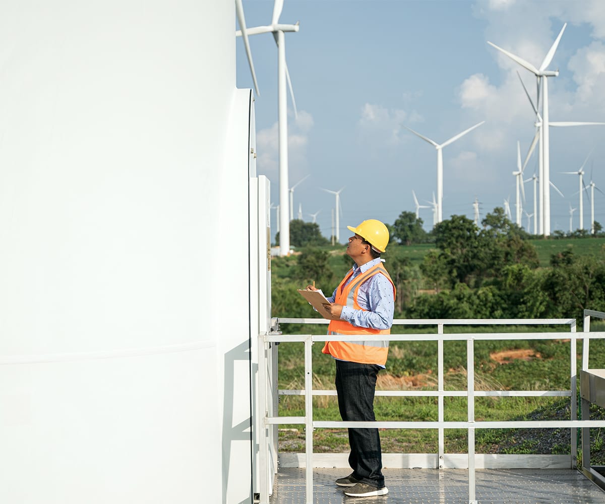 A man looking at a windmill.