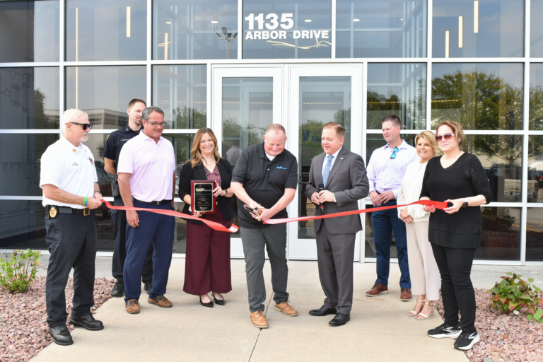 Ribbon cutting ceremony in front of the new 1135 G&W Electric building